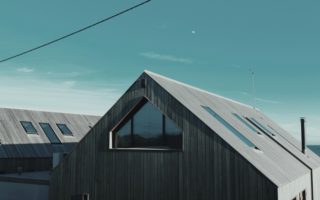 gray wooden house near body of water